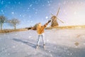 Girl having fun on ice in typical dutch landscape with windmill. Woman ice skating on rink outdoors in sunny snowy day Royalty Free Stock Photo