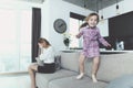 Girl Having Fun Jumping on Sofa when Mother Upset