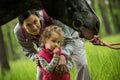 Girl having fun with mother and horse in the woods, young pretty girl with blond curly hair, freedom, joy, movement, outdoor, Royalty Free Stock Photo