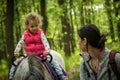 Girl having fun with mother and horse in the woods, young pretty girl with blond curly hair, freedom, joy, movement, outdoor, Royalty Free Stock Photo