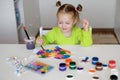 The girl is having fun painting with paints and a brush at the table Royalty Free Stock Photo