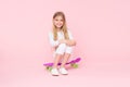 Girl having fun with penny board pink background. Kid adorable child long hair adore ride penny board. Ride penny board