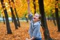 Girl having holiday in autumn city park, running, smiling, playing and having fun. Bright yellow trees and leaves