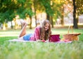 Girl having a picnic and surfing in the net Royalty Free Stock Photo