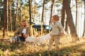 Girl is having a walk. Happy family of father, mother and little daughter is in the forest Royalty Free Stock Photo