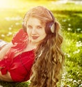 Girl in headphones catch rhythm music on green grass