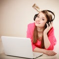 Girl with headphones and laptop listening to music Royalty Free Stock Photo