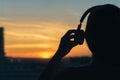 Girl in headphones listening to music in the city at sunset Royalty Free Stock Photo