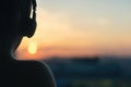 Girl in headphones listening to music in the city at sunset Royalty Free Stock Photo