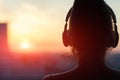 Girl in headphones listening to music in the city at sunset Royalty Free Stock Photo