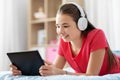 Girl in headphones listening to music on tablet pc Royalty Free Stock Photo