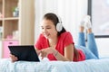 Girl in headphones listening to music on tablet pc Royalty Free Stock Photo