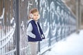 Girl in headphones near fence in winter in Park