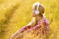 Girl with headphones sitting in the grass