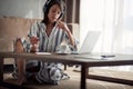 Girl with headphones using laptop in her home