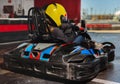 Girl in helmet driving kart on track