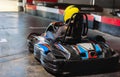 Girl in helmet driving kart on track