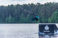 Girl with helmet and life vest rides a wakeboard on the lake