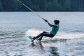 Girl with helmet and life vest rides a wakeboard on the lake