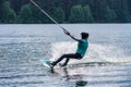 Girl with helmet and life vest rides a wakeboard on the lake