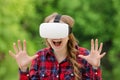 Girl in a helmet of virtual reality on a background of nature. D