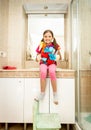 Girl helping with cleaning bathroom posing with cleansers Royalty Free Stock Photo