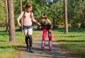 The girl helps the boy to roller-skate. Royalty Free Stock Photo