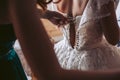 The girl helps the bride to dress white wedding dress