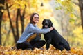 Girl with her dog labrador in autumn sunny park