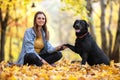 Girl with her dog labrador in autumn sunny park