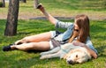 Girl and her dog selfie summer on a background of green grass.. Royalty Free Stock Photo
