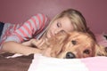 Girl and her dog sleeping together on a bedroom Royalty Free Stock Photo