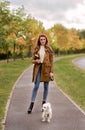 A girl and her dog walking in a park in autumn Royalty Free Stock Photo