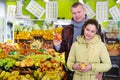 Girl with her father buying apples in fruit store