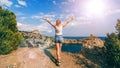 Girl with her hands up in nature in the summer against the sea on top of the mountains Royalty Free Stock Photo