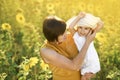 Girl in her mom`s arms laughs merrily while wearing big hat. Royalty Free Stock Photo