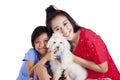 Girl and her mother hugging a maltese dog Royalty Free Stock Photo