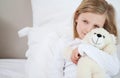 Girl with her teddy sitting on the bed Royalty Free Stock Photo