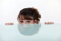 Girl hiding behind a table, Royalty Free Stock Photo