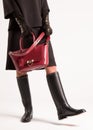 Girl in high black boots and a red bag Royalty Free Stock Photo
