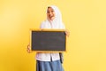 girl in high school uniform in veil carrying black chalkboard