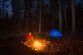 Girl hiker looking at the campfire