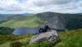 Girl hiker is looking at Guinness Lake Lough Tay -  a movie and series location, such as Vikings. Close to Dublin City, Royalty Free Stock Photo