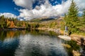 Girl hiker posing on the rock in the mountain lake in autumn colors Royalty Free Stock Photo