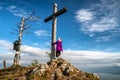 Girl hiker posing with wooden cross on top of the hill Pravnac in Slovakia Royalty Free Stock Photo