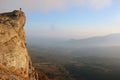 Girl hiker standing on edge of the cliff and enjoying valley vie