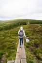 Girl hiker is walking on wooden path near Guinness Lake Lough Tay valley -  a movie and series location, such as Vikings. Royalty Free Stock Photo