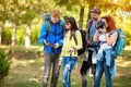 Girl from hikers group photographing until others looks at map