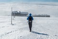 Girl hiking in Giant mountains towards Lucni bouda on a sunny winter day with string freezing wind, Krkonose, Czech republic Royalty Free Stock Photo