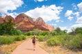 Girl on hiking trip in the red mountains, walking on pathway.